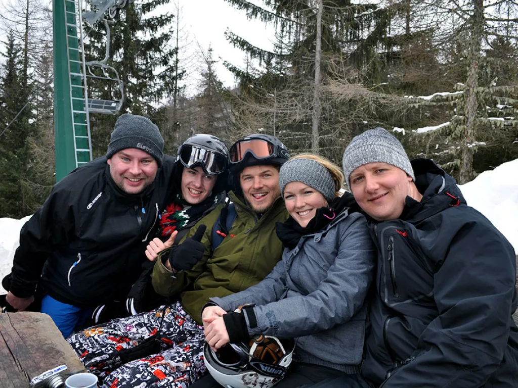 Gruppe sitzt auf einer Bank an der Talstation beisammen.